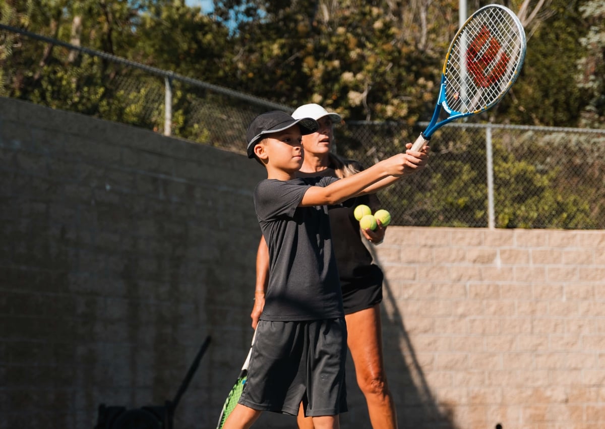 Green Dot player hitting overhead volley at the net