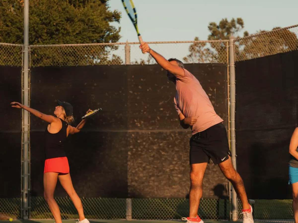Adult intermediate tennis players in mid-court training session