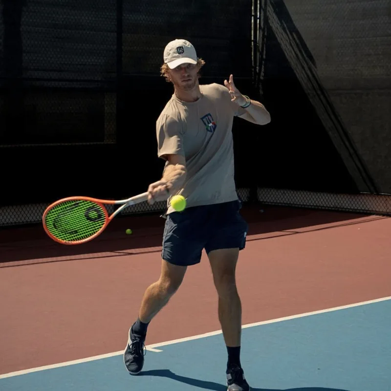Ryan Seggerman hitting a forehand on an outdoor hard court
