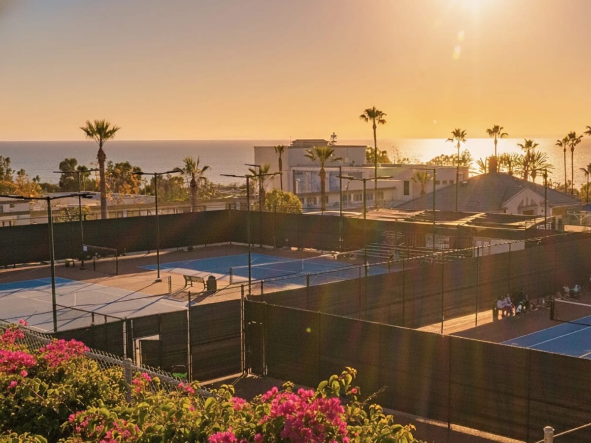 LBTA's courts at golden hour with the Pacific behind them, palms along the horizon