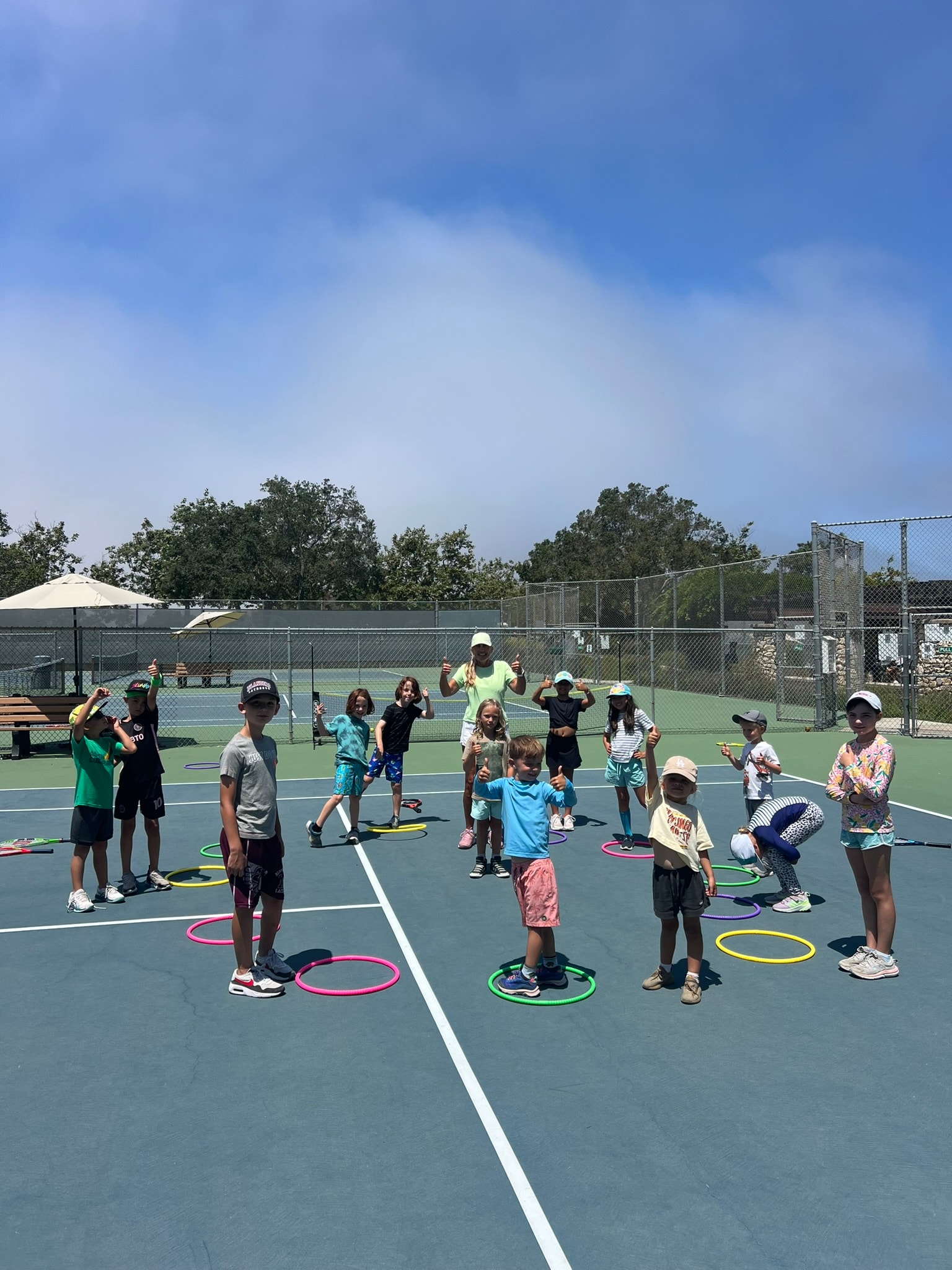 Campers doing field games and crafts under the shade pavilion